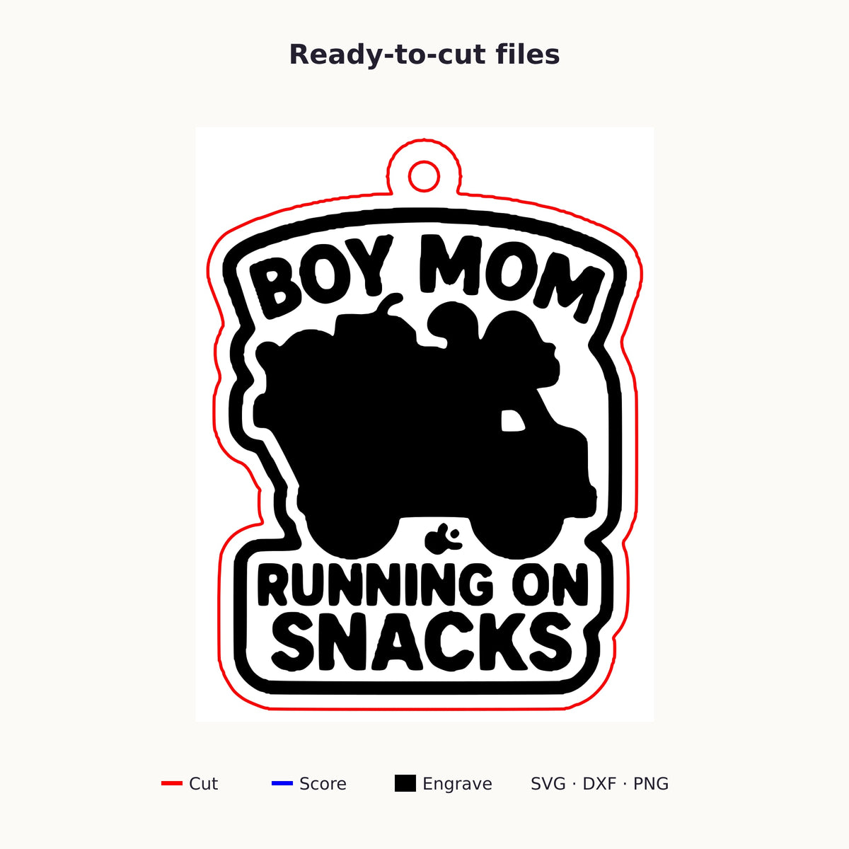 Laser cut wooden ornament engraved with the words Boy Mom Running On Snacks around a brown loaded truck silhouette, hanging on a thin cord against a blurred dark green background.