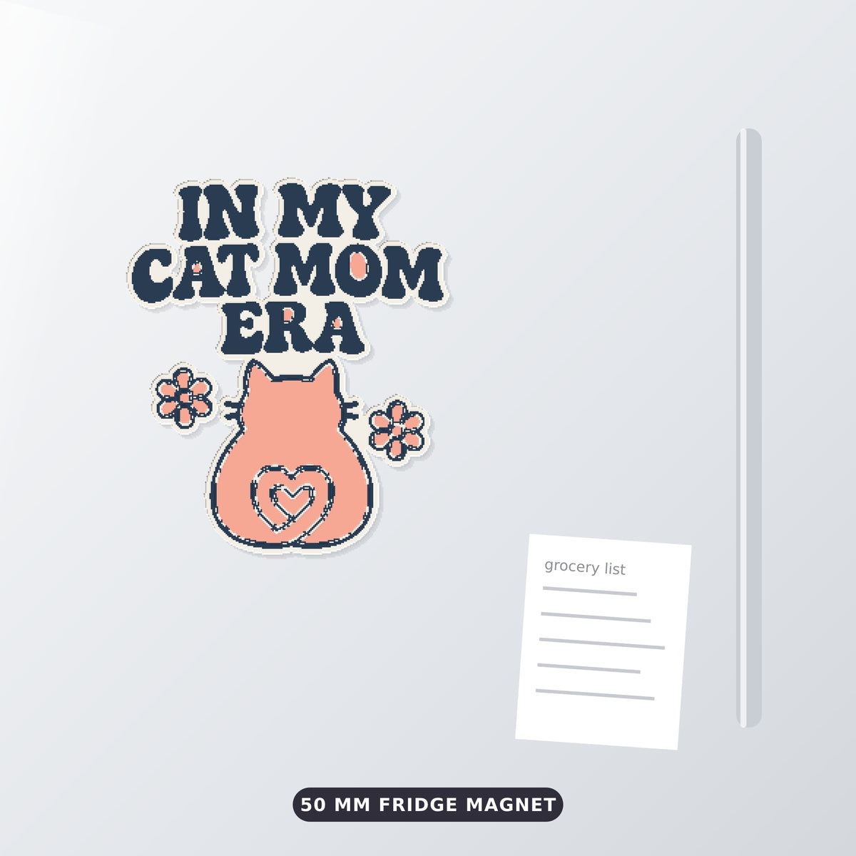 Pixel-style ornament with navy retro wavy text "In My Cat Mom Era" above a pink cat seen from behind with a heart-shaped tail and two flowers, on a dark green bokeh background labeled 75 mm ornament, 4 colors.