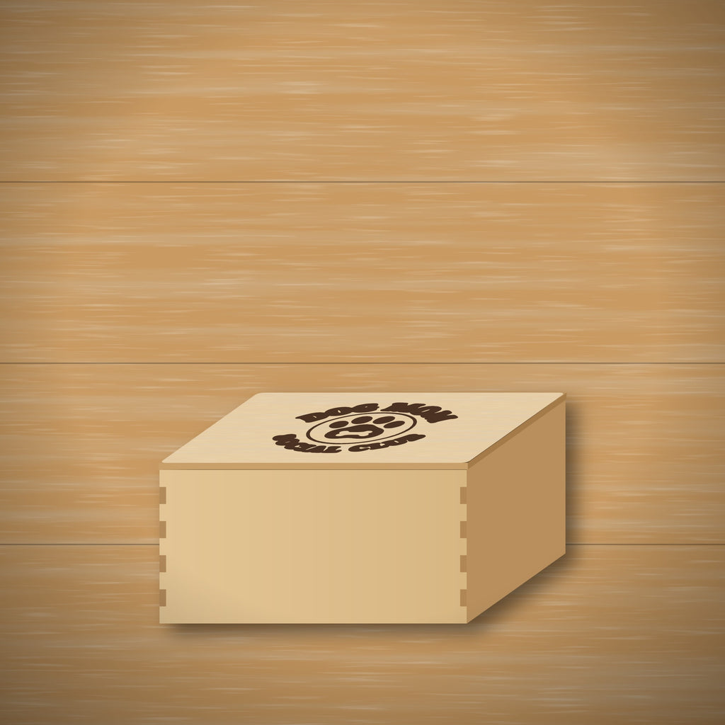 Round wooden laser cut ornament engraved with the words Dog Mom Social Club around a paw print with a bone, hanging on a thin cord against a dark green background with golden bokeh lights.