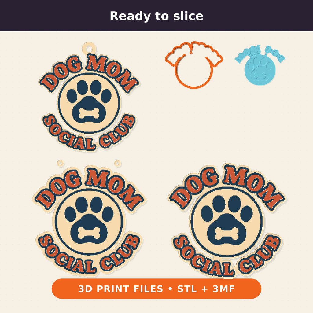 Round Dog Mom Social Club ornament with an orange retro lettering border and a navy paw print with a bone on a cream badge, hanging on a gold string against a dark green background with golden bokeh lights.