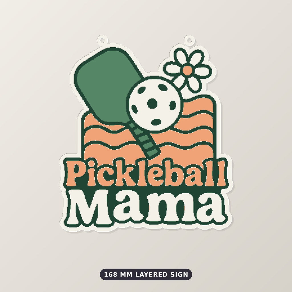 Retro Pickleball Mama ornament with a green paddle, white ball, daisy and peach wavy lines on a dark green blurred background, labeled 75 mm ornament, 4 colors.