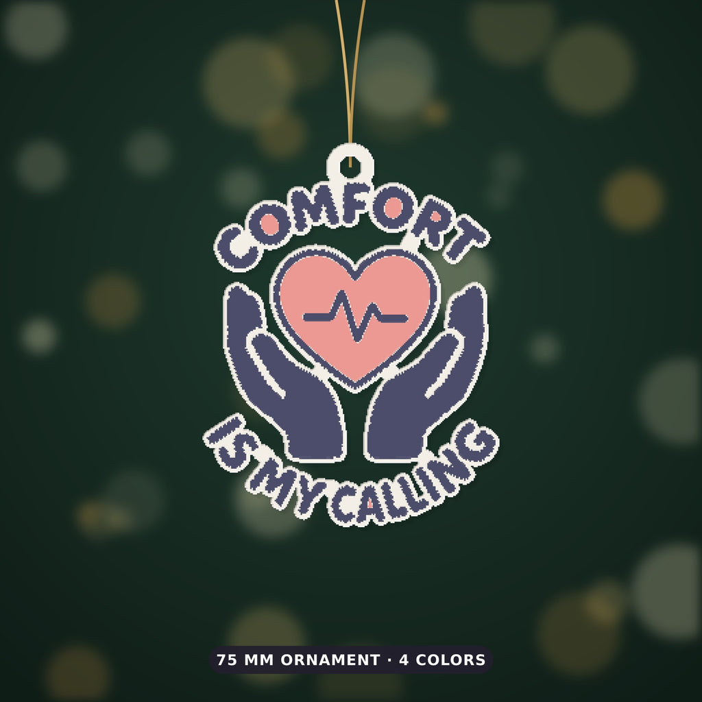 Ornament-shaped design with a pink heart and heartbeat line held by two navy hands, surrounded by the words Comfort Is My Calling on a dark green background labeled 75 mm ornament, 4 colors.