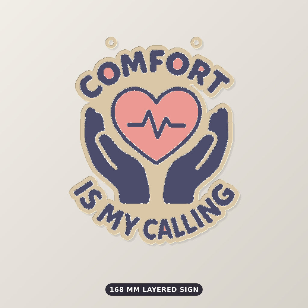 Ornament-shaped design with a pink heart and heartbeat line held by two navy hands, surrounded by the words Comfort Is My Calling on a dark green background labeled 75 mm ornament, 4 colors.