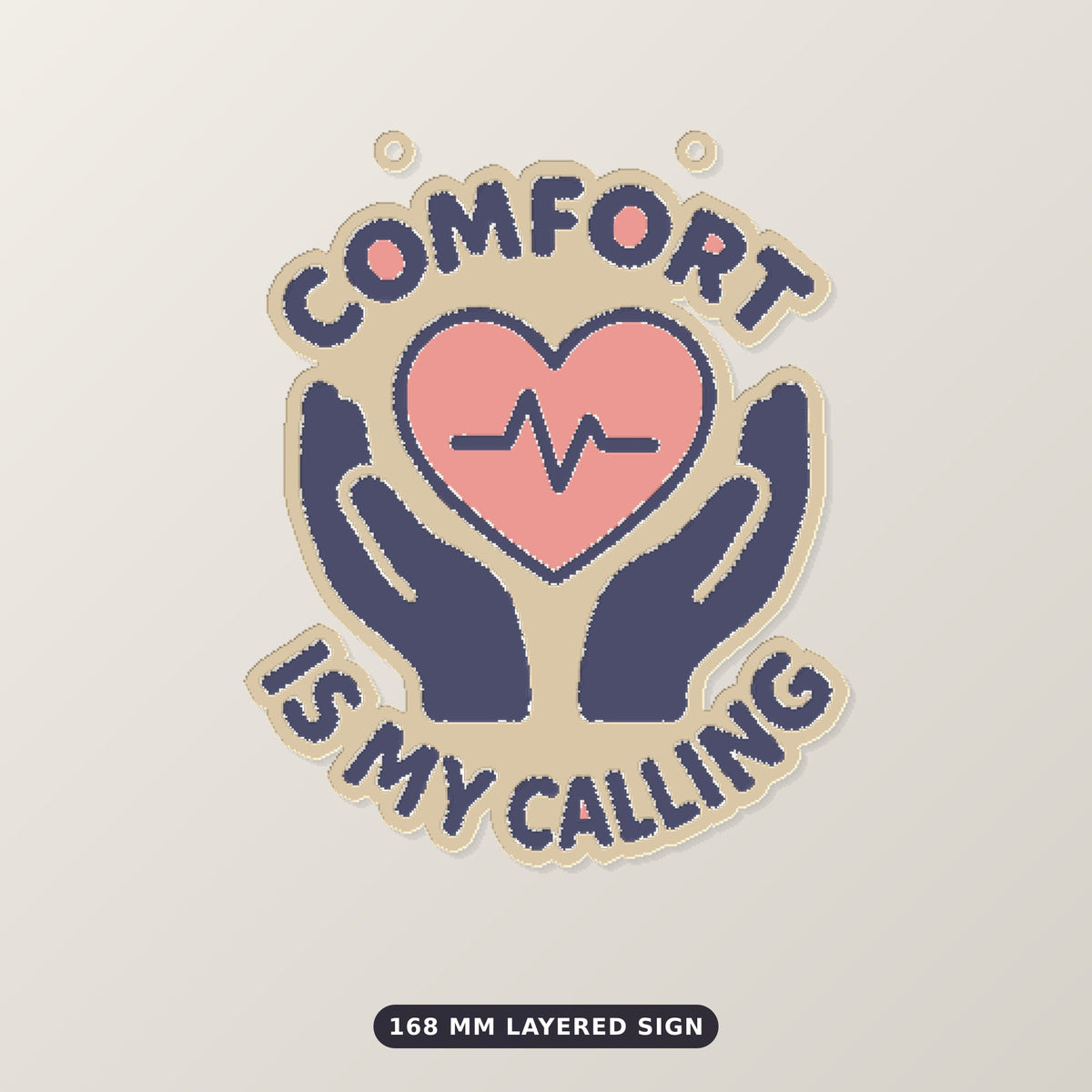 Ornament-shaped design with a pink heart and heartbeat line held by two navy hands, surrounded by the words Comfort Is My Calling on a dark green background labeled 75 mm ornament, 4 colors.
