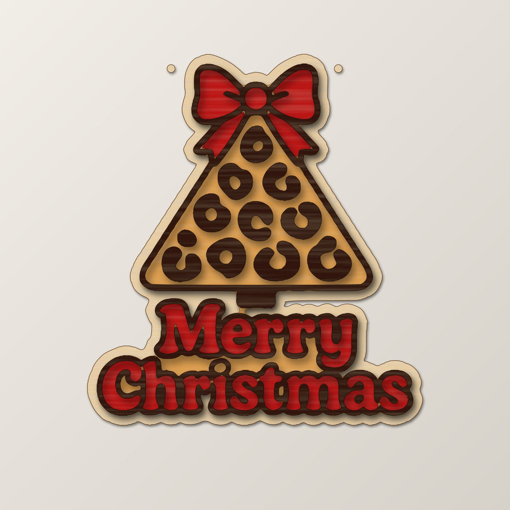 Laser cut wooden Christmas ornament shaped like a leopard print tree with a bow on top and the words Merry Christmas below, hanging against a dark green blurred background.