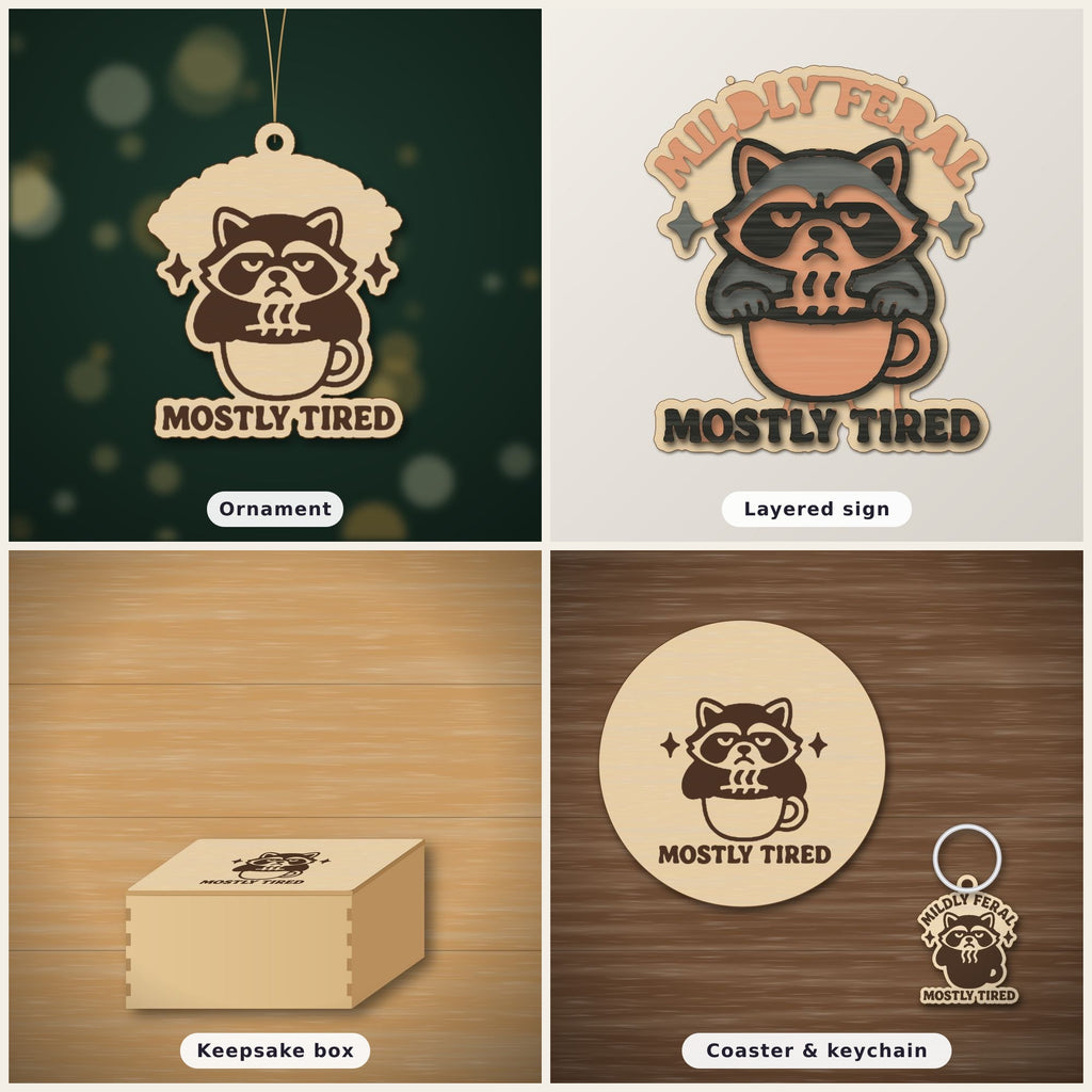A laser-cut wooden ornament showing a grumpy raccoon sitting in a coffee cup with sparkles above it and the words Mostly Tired engraved underneath, hanging on a gold string against a dark green background.