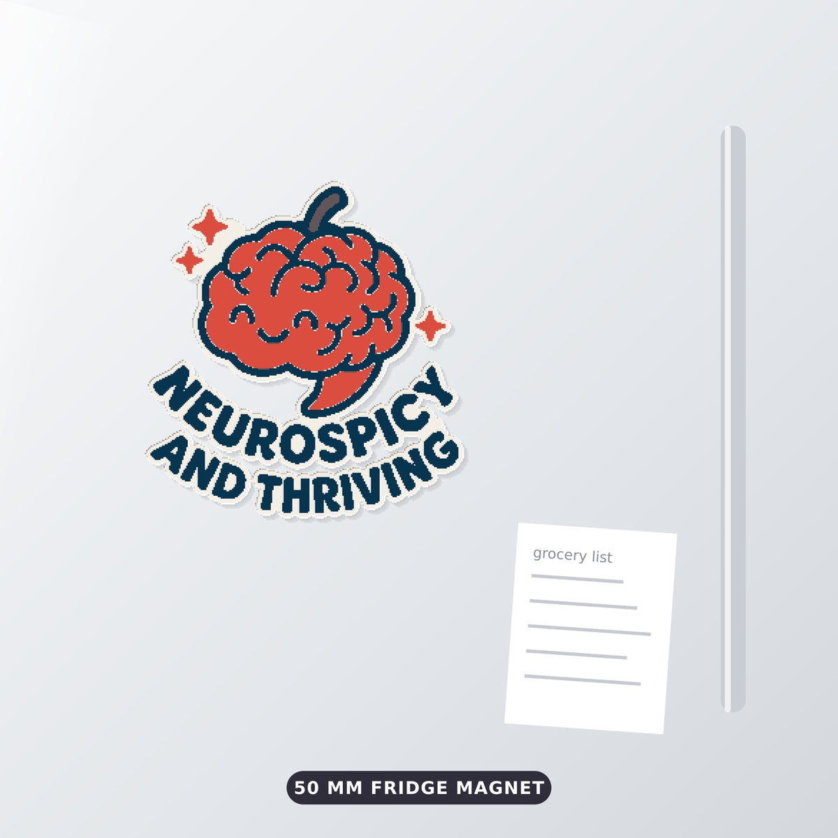 A 75 mm ornament of a smiling red chili-pepper brain with sparkles and the words Neurospicy and Thriving, hanging on a gold cord against a dark green bokeh background.