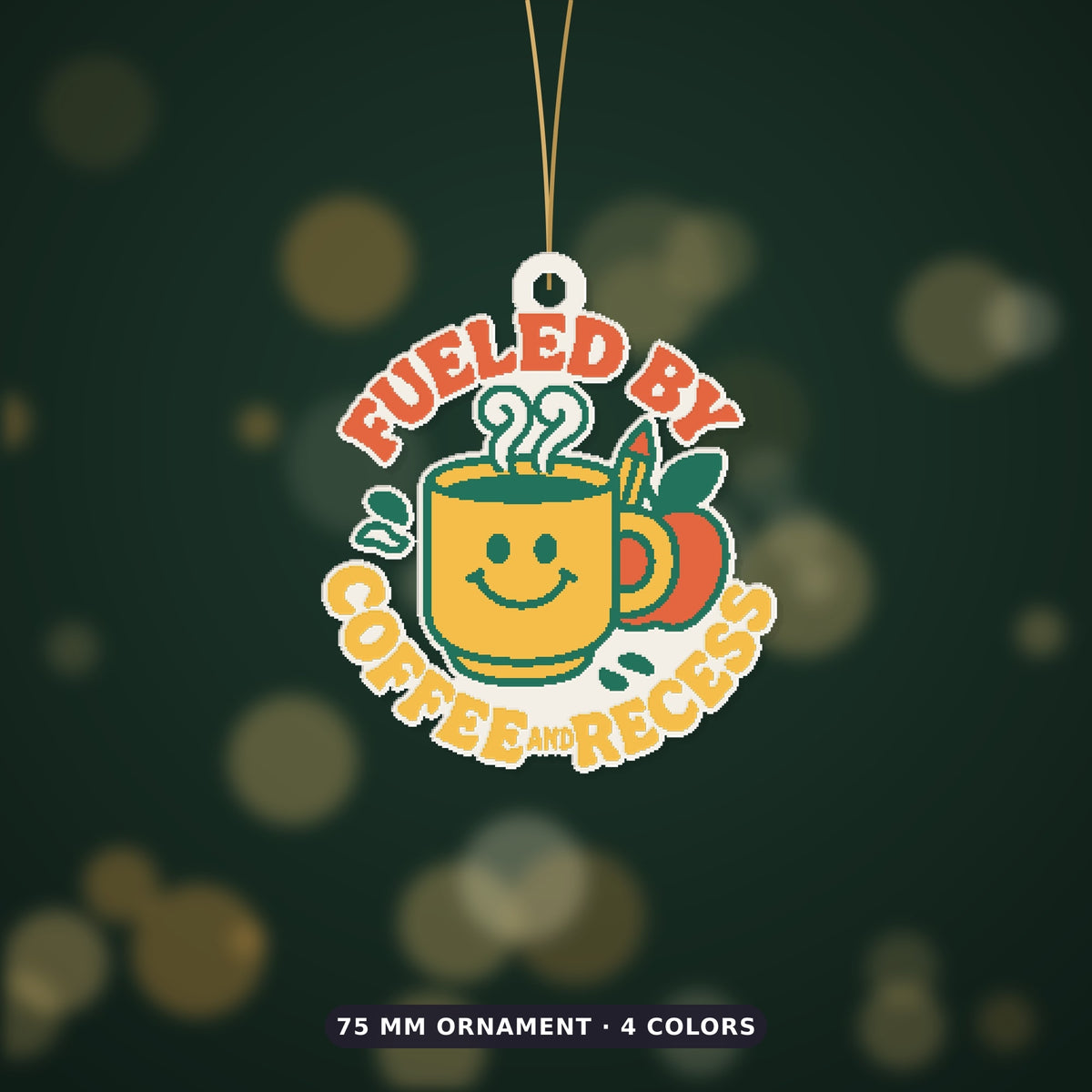 Round ornament with a smiling yellow coffee mug, green steam, an apple and a pencil, surrounded by the text Fueled by Coffee and Recess, on a dark green background with golden bokeh lights.