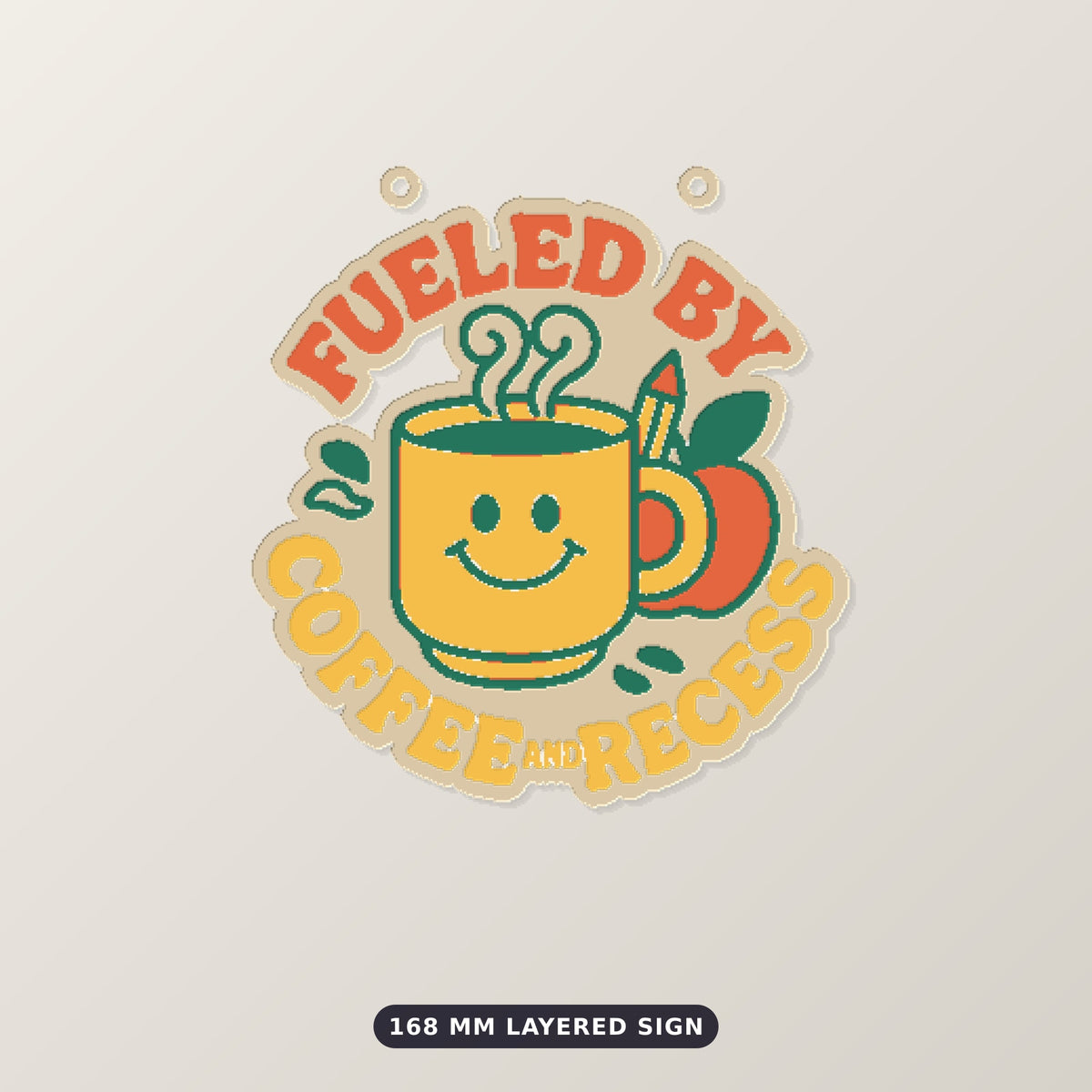 Round ornament with a smiling yellow coffee mug, green steam, an apple and a pencil, surrounded by the text Fueled by Coffee and Recess, on a dark green background with golden bokeh lights.