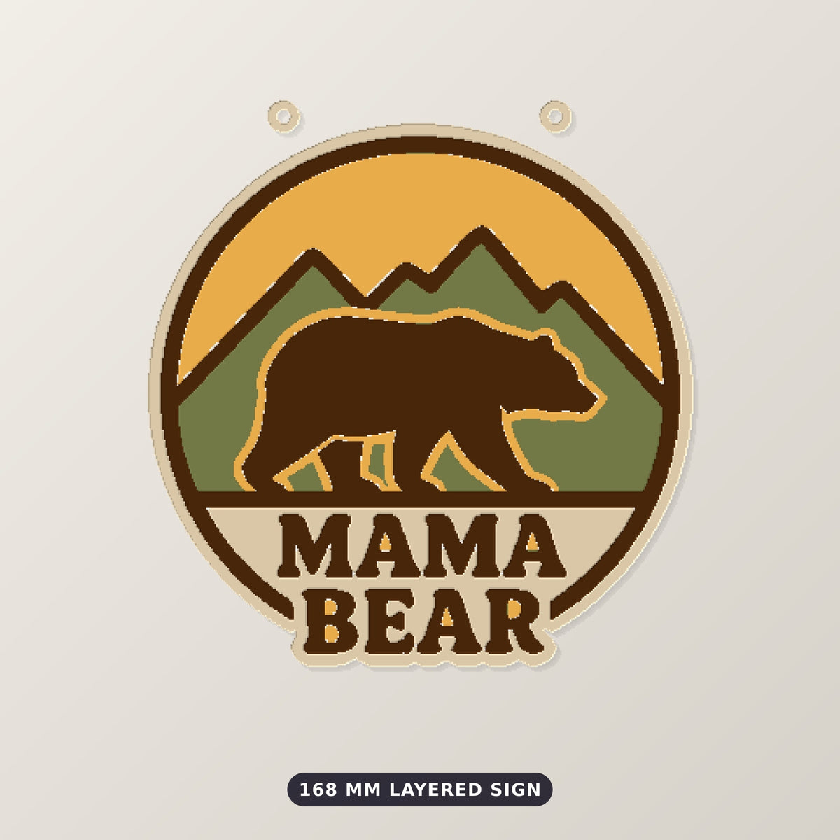 Round retro mama bear ornament showing a brown bear walking in front of green mountains and a yellow sunset, with the words Mama Bear below, hanging on a gold string against a dark green background.