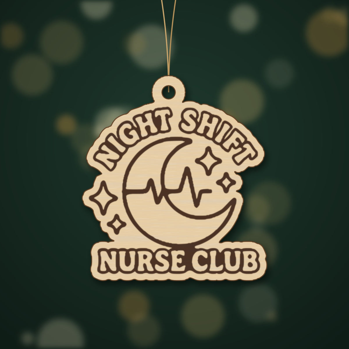 A round-cornered wooden laser cut ornament engraved with a crescent moon, heartbeat line and sparkles, with the words Night Shift Nurse Club, hanging on a gold string against a dark green background with soft lights.