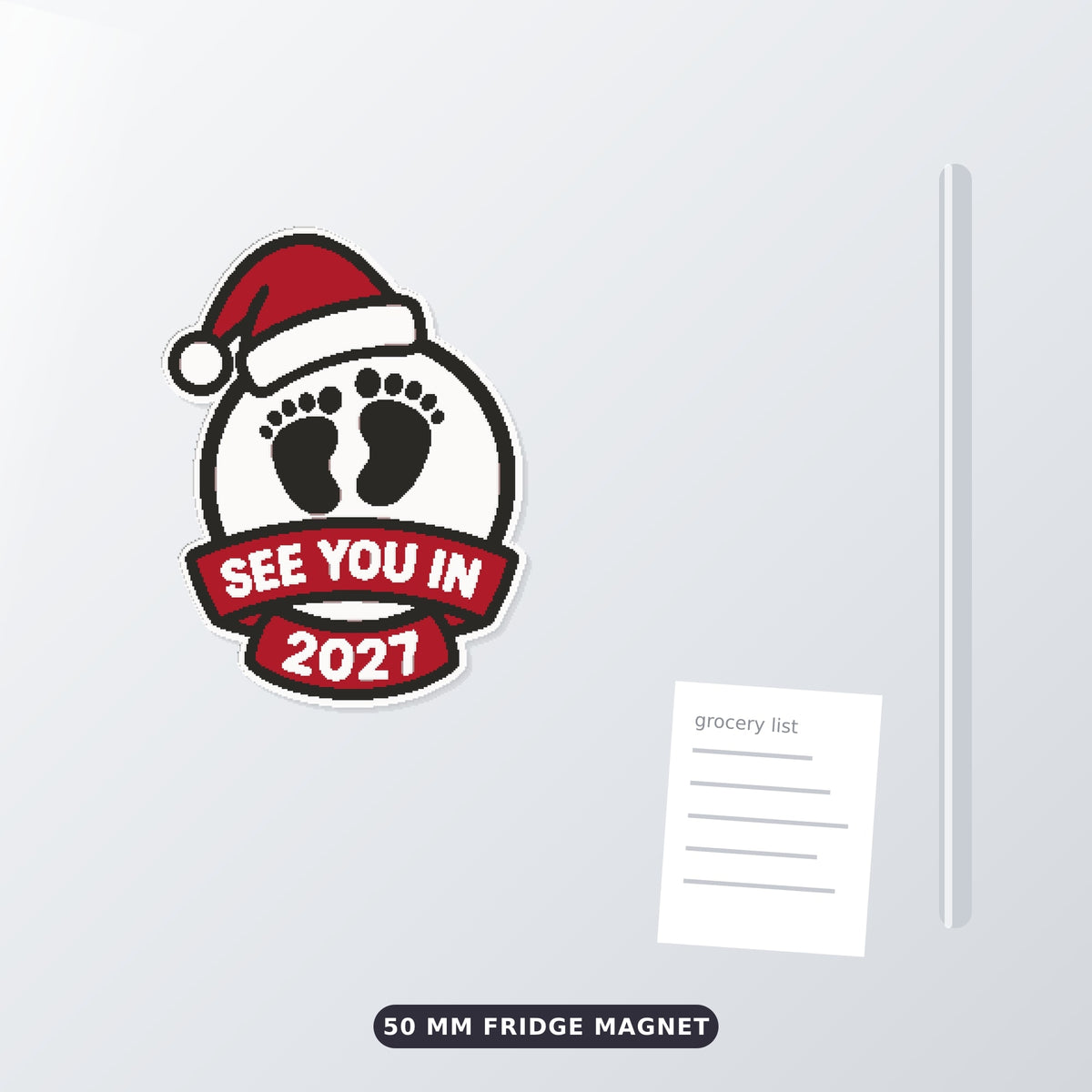 Round white ornament with black baby footprints, a red Santa hat and a red ribbon banner reading See You In 2027, hanging on a gold string against a dark green background.