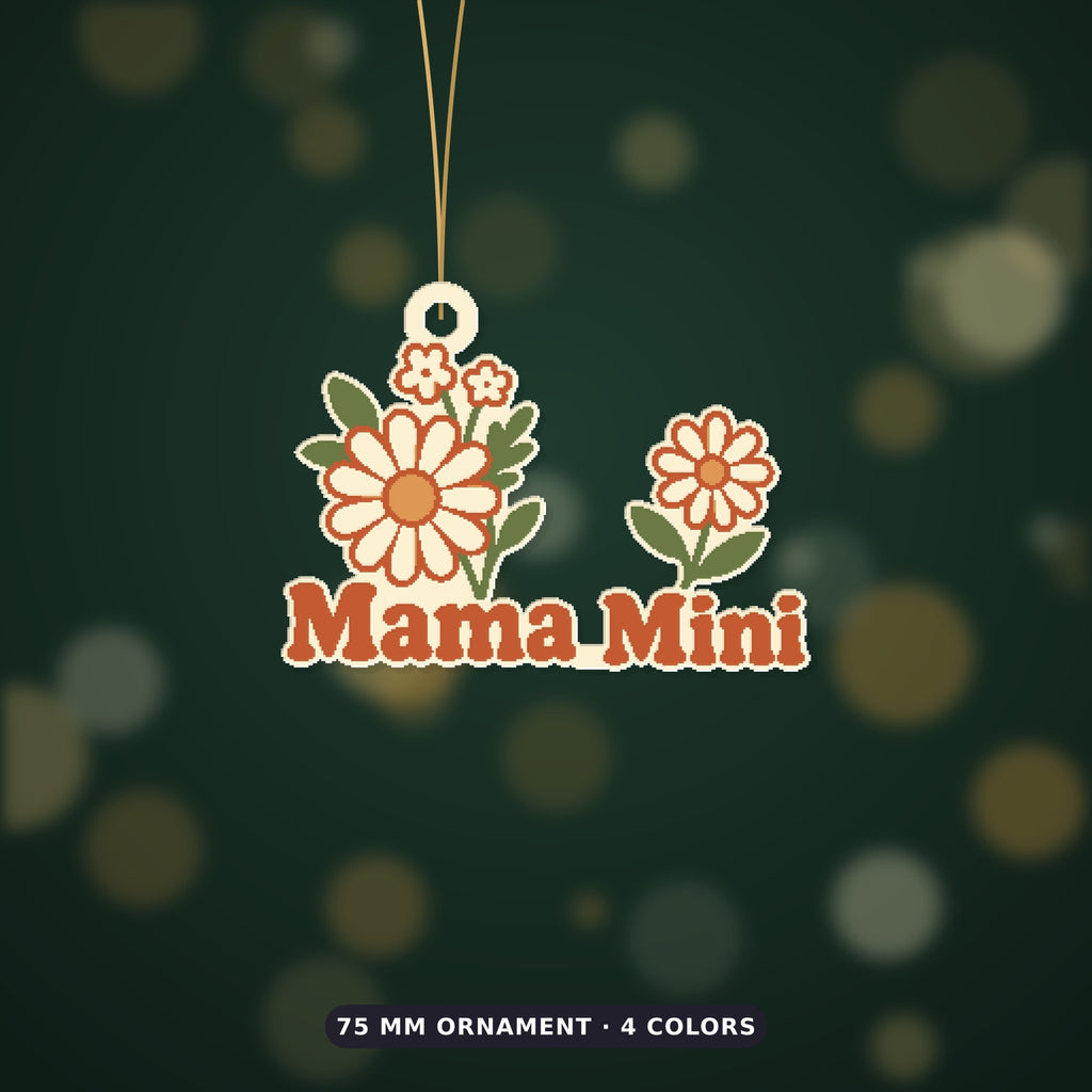 Retro floral ornament with cream and orange wildflowers and rust-red "Mama Mini" lettering, hanging from a gold string against a dark green background, labeled 75 mm ornament, 4 colors.