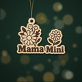 Wooden laser cut ornament with engraved daisy bouquet and single daisy, reading Mama Mini, hanging by a thin cord against a dark green background with golden bokeh lights.