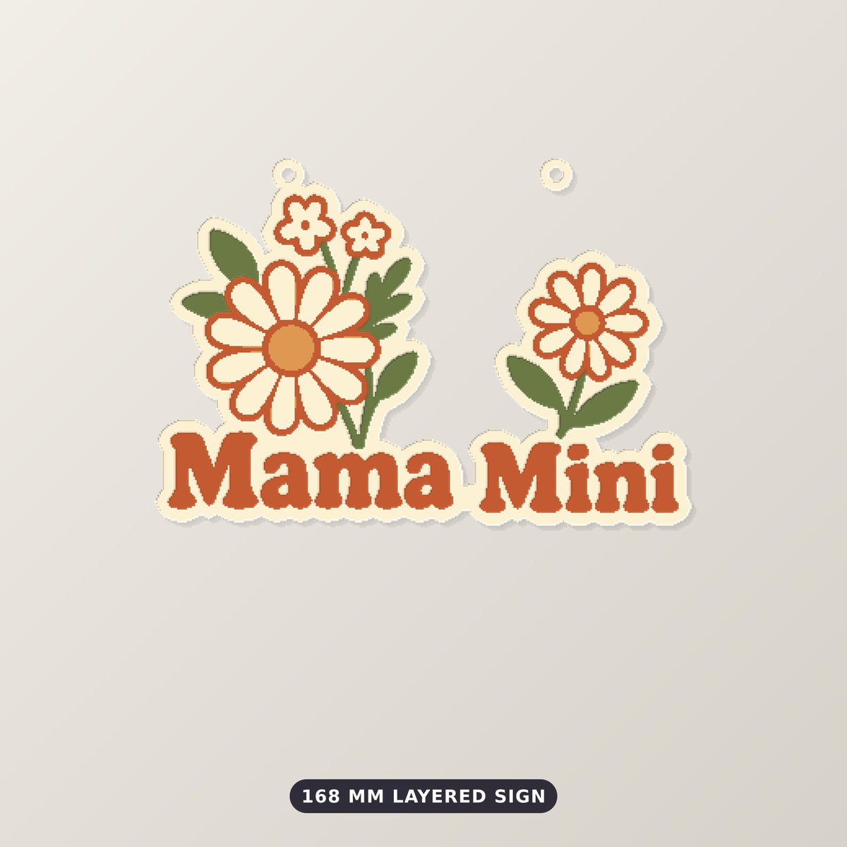 Retro floral ornament with cream and orange wildflowers and rust-red "Mama Mini" lettering, hanging from a gold string against a dark green background, labeled 75 mm ornament, 4 colors.